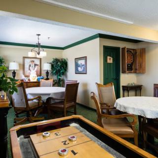 A cozy dining room with tables, chairs, and warm decor.