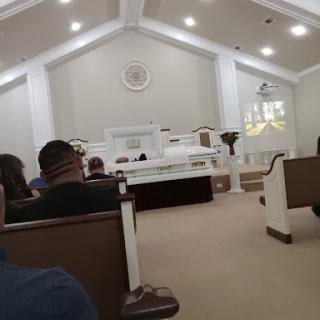 A view of the interior of a church with attendees seated.
