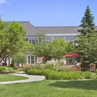 A beautiful residential house surrounded by a well-maintained garden and lush greenery.