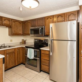 A modern kitchen with stainless steel appliances and wood cabinetry.