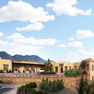 A desert building with scenic mountain views under a partly cloudy sky.