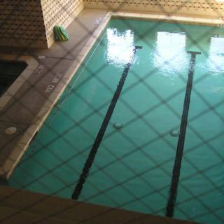 An indoor swimming pool with lane markings and tiled surroundings.