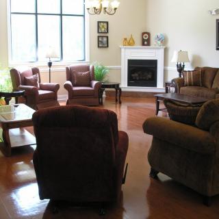 A cozy living room with multiple chairs and a sofa arranged around a fireplace.