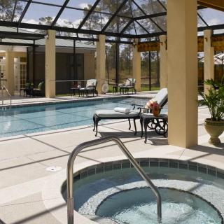 A luxurious indoor pool area featuring a hot tub and comfortable lounge chairs, perfect for relaxation and leisure.