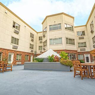 A serene courtyard with outdoor seating surrounded by a multi-story building.