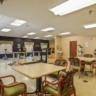 A spacious rehabilitation center equipped with exercise equipment and comfortable seating.
