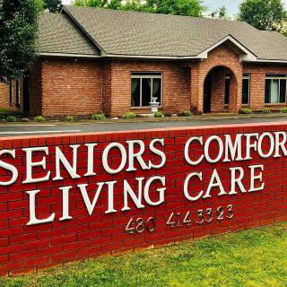 A red brick seniors living care facility with a prominent sign in front.