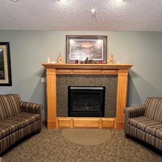 A cozy living room featuring a fireplace and comfortable striped sofas.