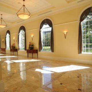 A spacious and elegant hall with large arched windows allowing sunlight to flood the room.