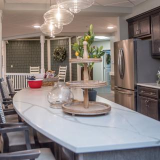 A modern kitchen interior featuring a spacious island with a sleek countertop, stainless steel appliances, and elegant pendant lighting.