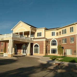 A beautiful two-story residential building with a welcoming entrance and surrounded by greenery.