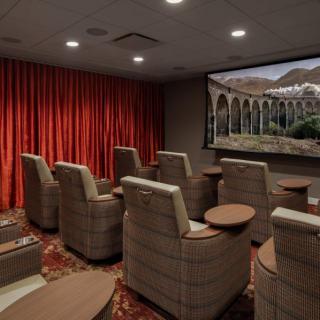 A cozy home theater room with comfortable seating and a large screen.