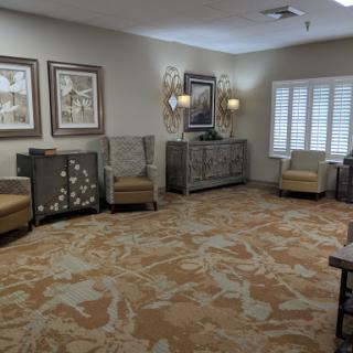 A cozy waiting area featuring comfortable seating, decorative artwork, and elegant furnishings.