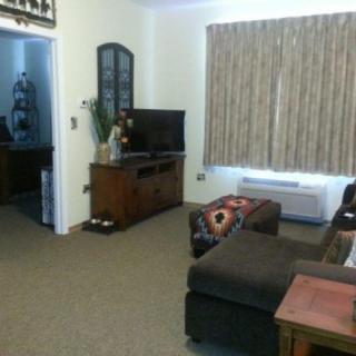 A cozy living room with a sofa, television, and curtains.