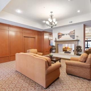A cozy living room featuring a set of sofas, a fireplace, and a chandelier.