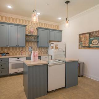 A cozy kitchen with blue cabinets and a central island, featuring retro decor and modern appliances.