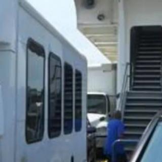 A bus parked next to stairs on a sunny day.