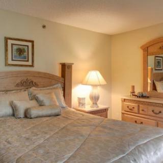 A cozy and inviting bedroom featuring a comfortable bed, decorative pillows, and warm lighting.