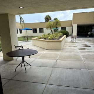 A serene outdoor courtyard featuring a small table and surrounding greenery.