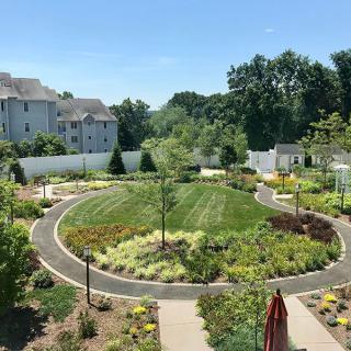 A beautifully landscaped garden with circular pathways and lush greenery.