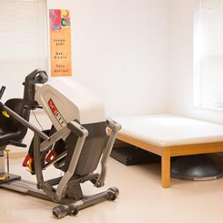 A fitness studio featuring rehabilitation exercise equipment and a training area.
