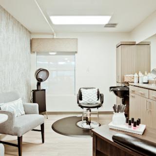 A sleek and modern hair salon interior featuring comfortable seating and elegant design.