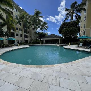 A tranquil outdoor swimming pool surrounded by palm trees at a tropical resort.
