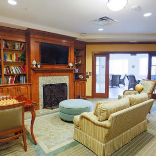 A cozy living room with a fireplace, bookshelves, and comfortable seating.