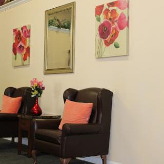 A cozy seating area featuring decorative art and flowers.
