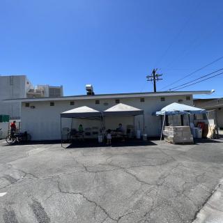 A sunny day in a parking lot with tents set up outside a building.