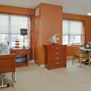 A cozy and well-lit living space featuring wooden furniture and warm orange walls.