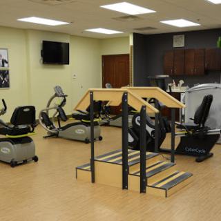 A well-equipped gym featuring various exercise machines and a stair stepper.