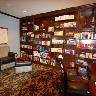 A cozy library with bookshelves, an armchair, and a desk.
