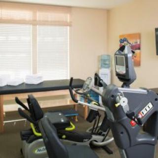 A rehabilitation room equipped with exercise machines and a treatment table.