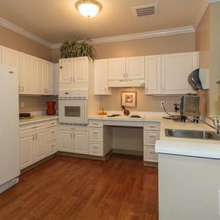 A modern kitchen with white cabinets and wood flooring.