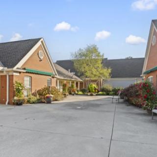 A suburban residential area with houses lined along a driveway on a clear day.