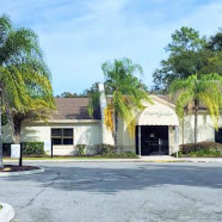 A commercial building surrounded by palm trees on a sunny day.