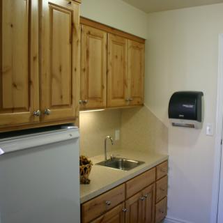 A compact kitchen space with wooden cabinets and a small sink.