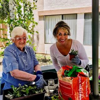 Two women enjoying gardening together outdoors.
