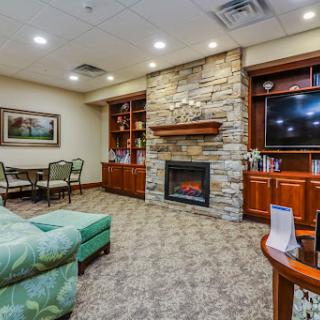 A cozy living room featuring a stone fireplace, comfortable seating, and a welcoming atmosphere.