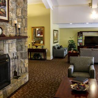 A cozy living room featuring a stone fireplace and comfortable seating arrangement.