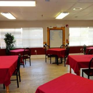 A cozy dining area with tables covered in red tablecloths.