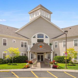 A two-story building with a prominent entrance and well-maintained landscaping on a clear day.