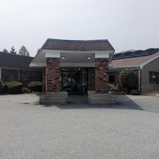 A view of a building entrance with a brick facade and surrounding landscaping.