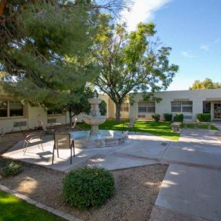 A peaceful courtyard with benches and trees on a sunny day.