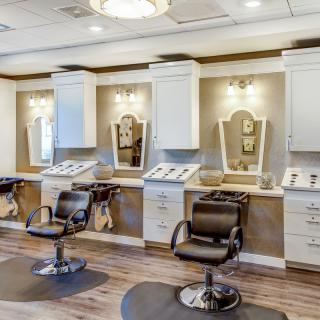 A modern salon interior with chairs and mirrors neatly arranged.