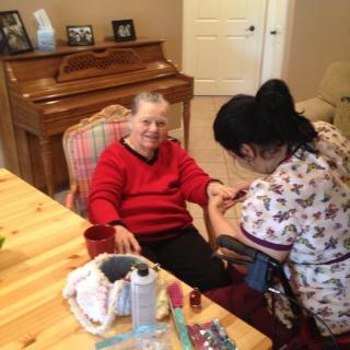 A nurse checks the blood pressure of an elderly person in a home setting.
