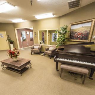 A cozy lobby featuring a piano, comfortable seating, and decorative artwork.
