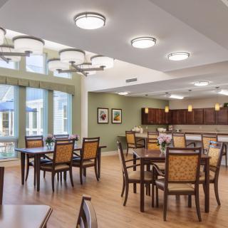 A modern dining area with elegant furniture and ample lighting.