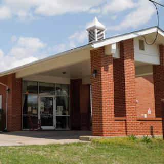 A modern brick building with a welcoming entrance under a clear sky.